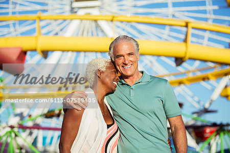 Portrait of hugging senior couple at amusement park