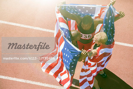 Track and field athletes holding American flags on track