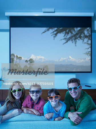 Family watching 3D television in living room