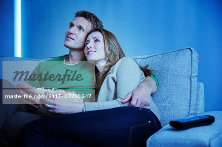 Couple watching television on sofa