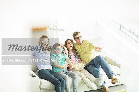 Family watching 3D television in living room