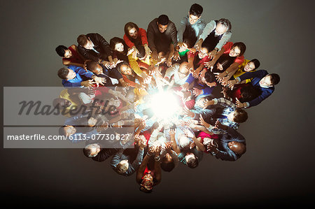 Diverse workers around bright light Diverse workers around bright light