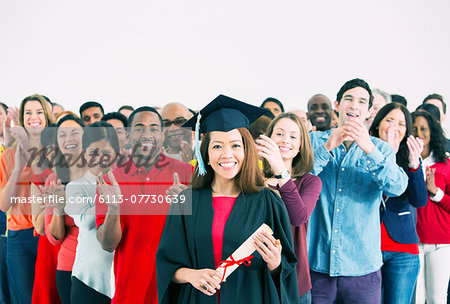 Crowd clapping behind happy graduate