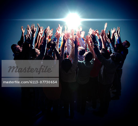Diverse group reaching for bright light