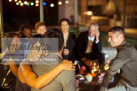 Couple hugging at party