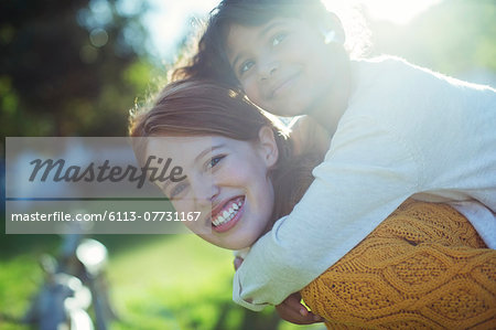 Mother carrying daughter on shoulders