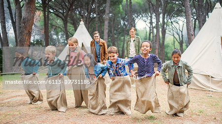 Children having sack race at campsite