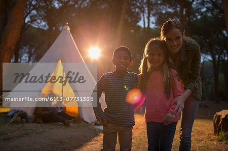 Students and teacher smiling at campsite