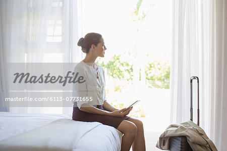 Businesswoman using digital tablet in hotel room