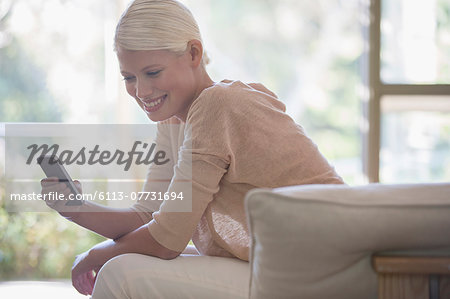 Woman using cell phone on sofa