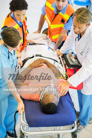 Doctor, nurse and paramedics examining man on stretcher