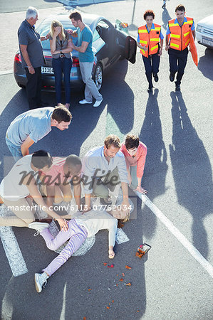 People examining injured girl on street