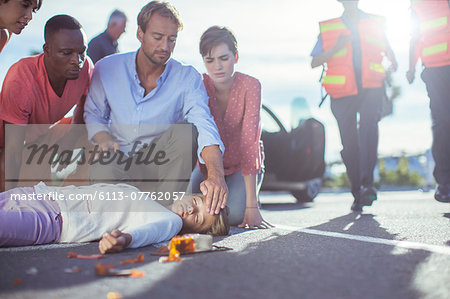 People examining injured girl on street