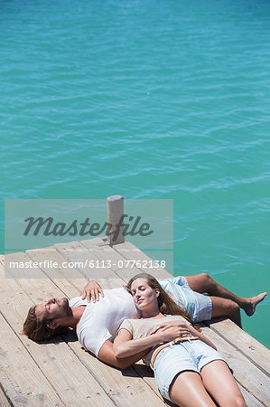 Couple relaxing together on wooden dock