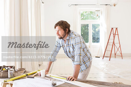 Man overlooking construction table in living space