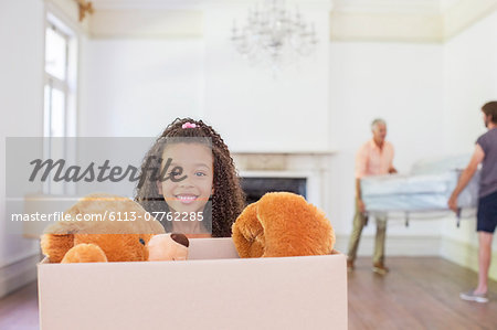 Young girl carrying box with teddy bear inside