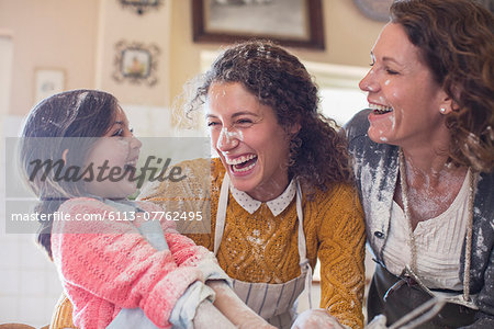 Three generations of women playing in the kitchen