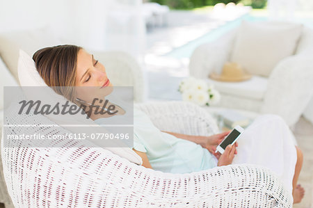 Woman listening to music in wicker chair