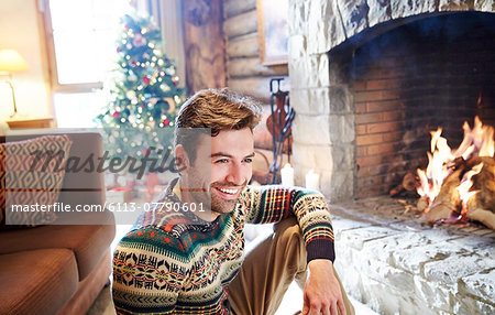Man in warm sweater enjoying fireplace