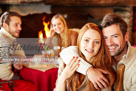 Couple hugging at restaurant with friends
