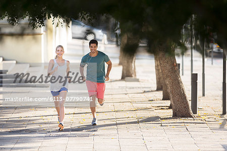 Couple running through city streets together