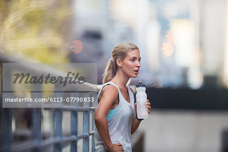 Woman resting after exercising on city street