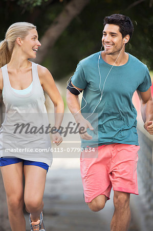 Couple running through city streets together
