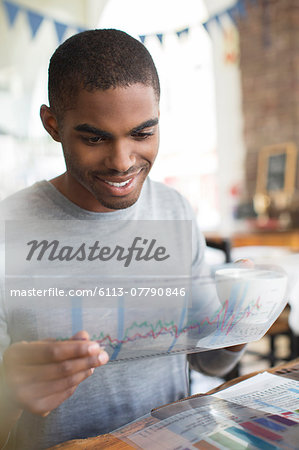 Businessman examining transparency at lunch meeting in cafe