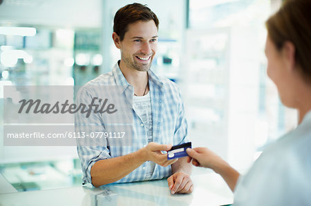 Man paying with credit card in drugstore Man paying with credit card in drugstore