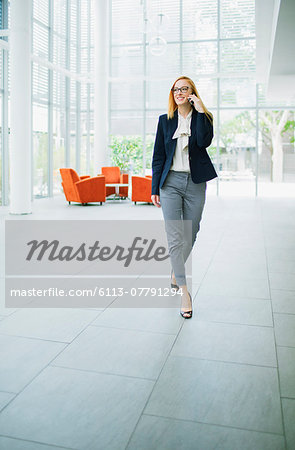 Businesswoman talking on cell phone in office building