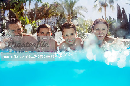 Portrait of family with two children in swimming pool