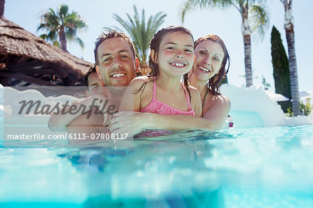 Happy family in a swimsuit in the pool Stock Photo by