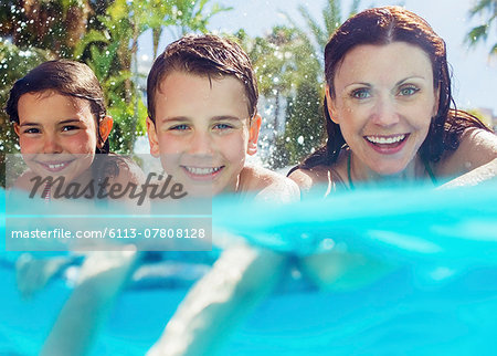 Portrait of mother with her two children in swimming pool Portrait of mother with her two children in swimming pool