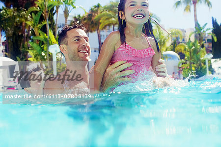 Father with daughter and son playing in swimming pool