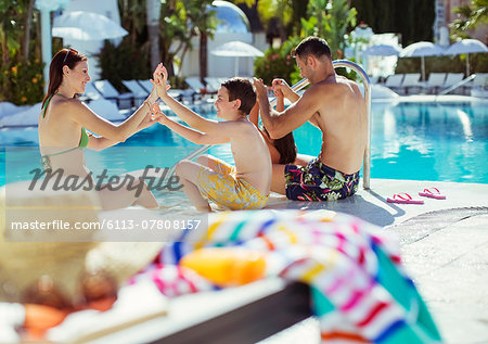 Family with two children enjoying themselves by swimming pool