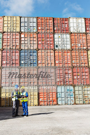 Businessman and worker talking near cargo containers Businessman and worker talking near cargo containers