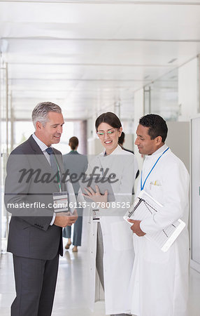 Scientists and businessman using digital tablet in hallway