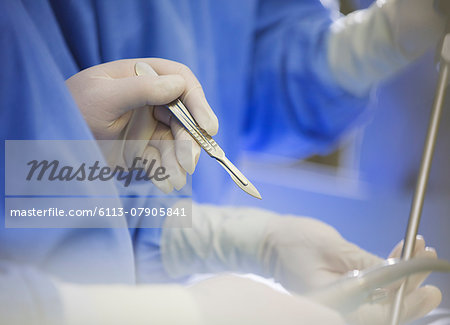 Mature surgeon using scalpel during surgery