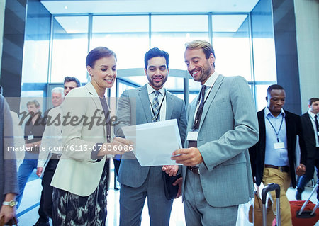Portrait of businesswoman and two businessmen standing in lobby of conference center