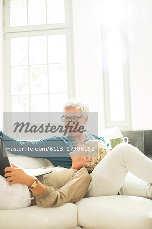 Older couple relaxing together on living room sofa Older couple relaxing together on living room sofa