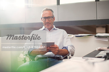 Businessman using digital tablet at office desk