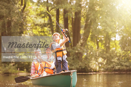 Boy, father and grandfather fishing from canoe on lake Boy, father and grandfather fishing from canoe on lake