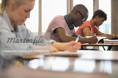 View of students sitting at desks during test in classroom