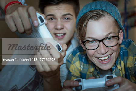 Two teenage boys playing together video game