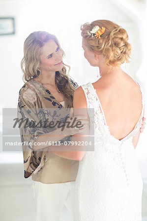 Matron of honor and bride talking in domestic room