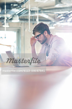 Focused businessman working at laptop