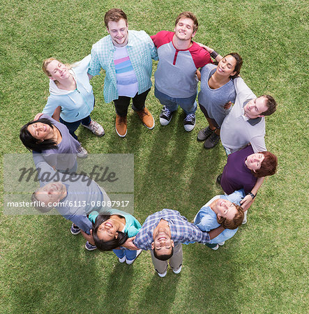 Team forming connected circle basking in sunny field Team forming connected circle basking in sunny field