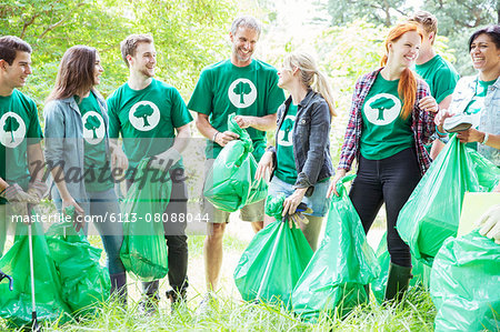 Smiling environmentalist volunteers picking up trash