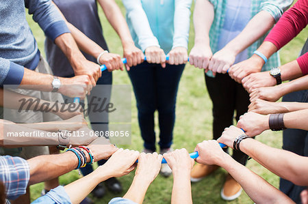 Team connected in circle around plastic hoop Team connected in circle around plastic hoop
