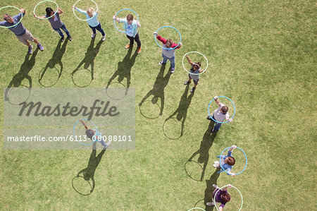 Woman leading team with plastic hoops overhead Woman leading team with plastic hoops overhead